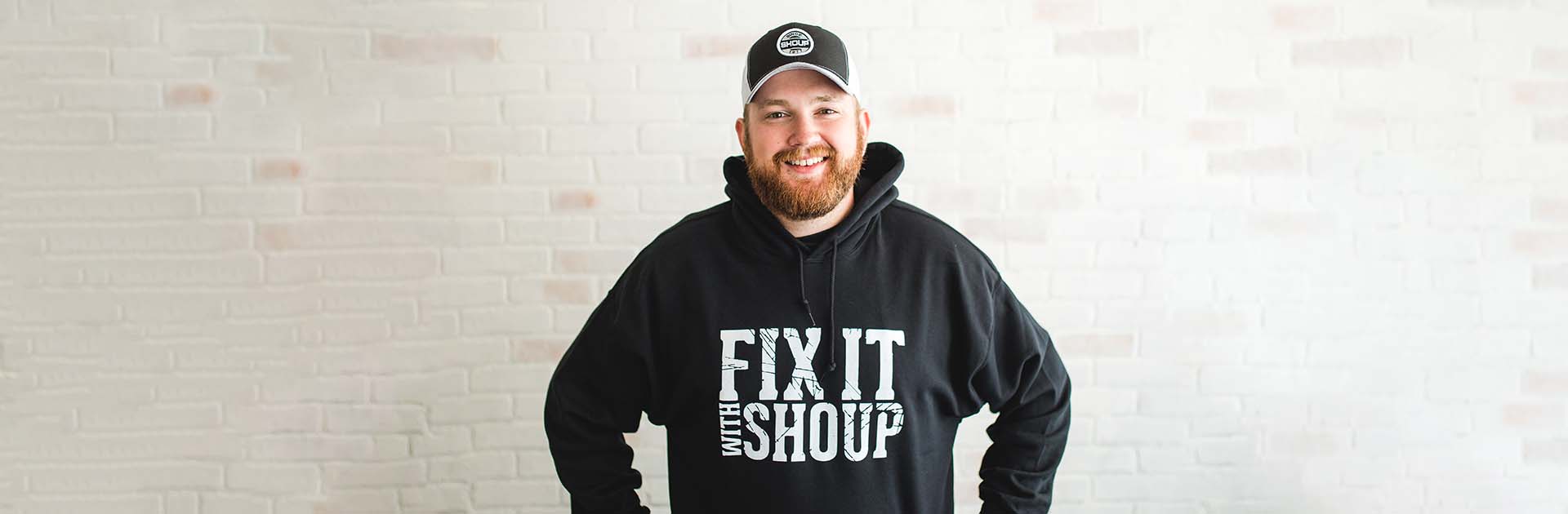 man wearing black Fix It with Shoup hoodie